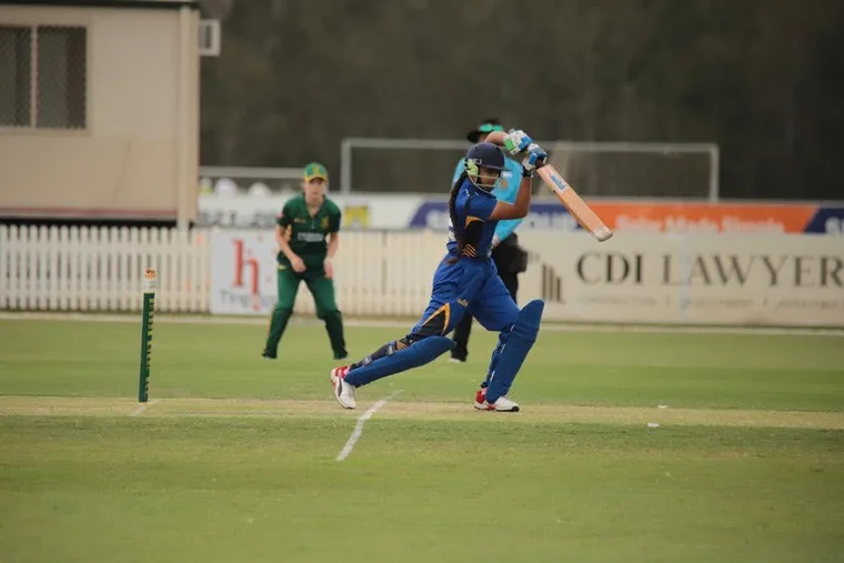 A junior playing a cricket shot in a match